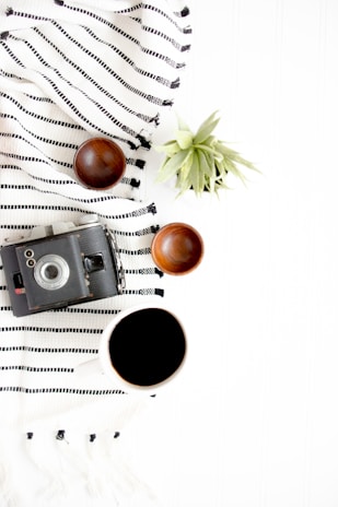 black and gray camera beside on brown wooden bowls