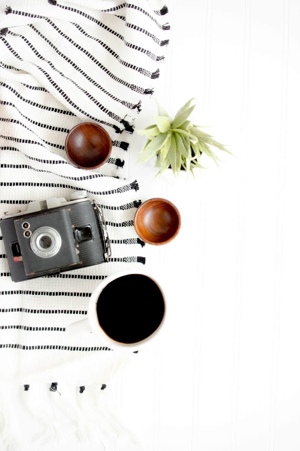 black and gray camera beside on brown wooden bowls