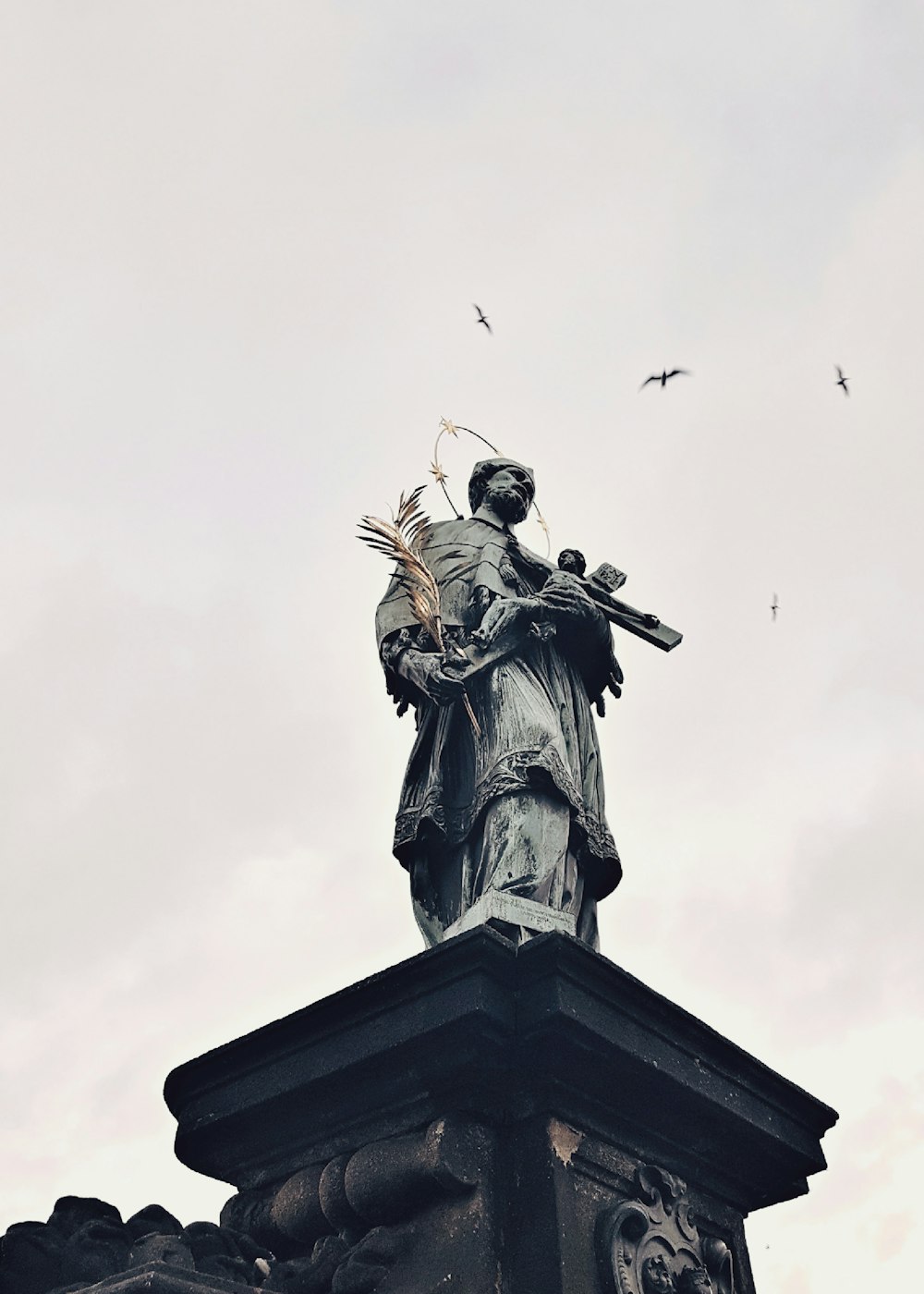 photo en contre-plongée d’une statue en béton gris pendant la journée