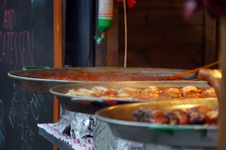 A warm, inviting restaurant counter with grilled chicken and meatballs on display.