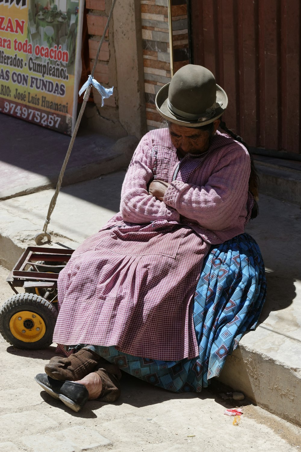 person sitting white sleeping on gray concrete street pathway during daytime