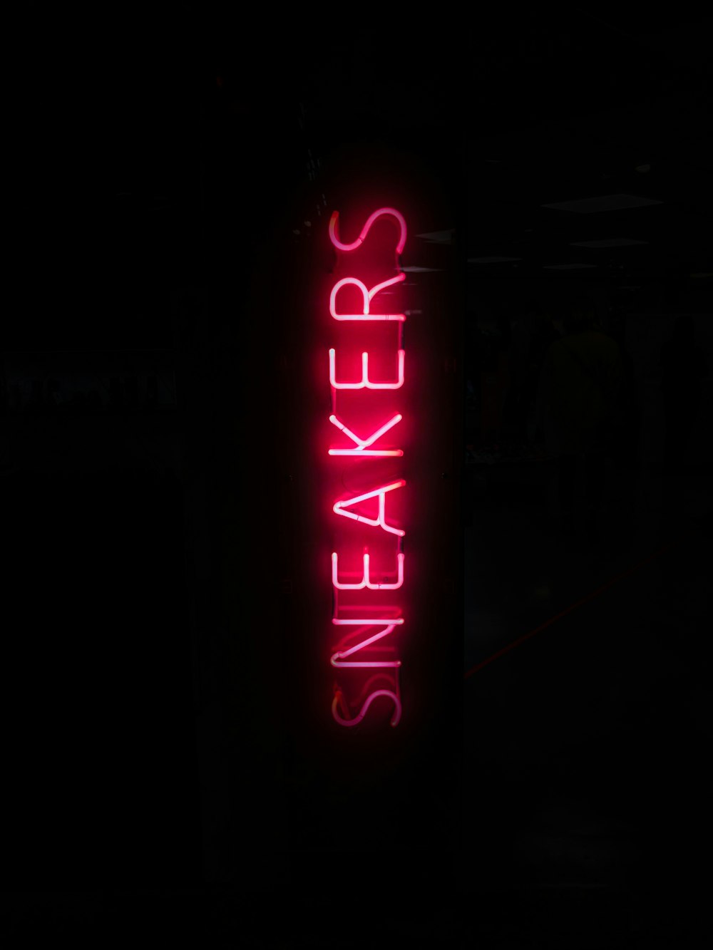 turned on red sneakers neon light in dark place