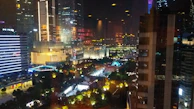 A vibrant urban scene at dusk with glowing streetlights and reflections.