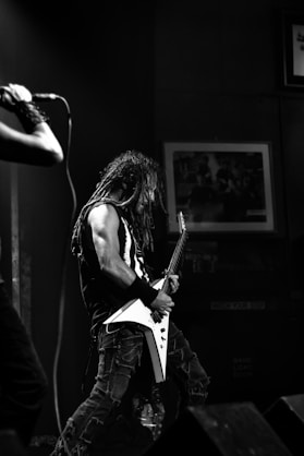 man playing electric guitar inside black room