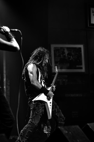 man playing electric guitar inside black room