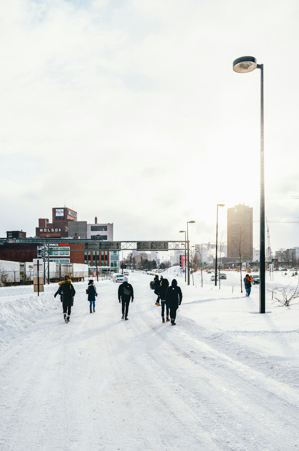 people walking on snow covered road during day time