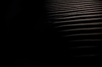 Close-up of overlapping shadows on a dark surface with mysterious glowing lines.