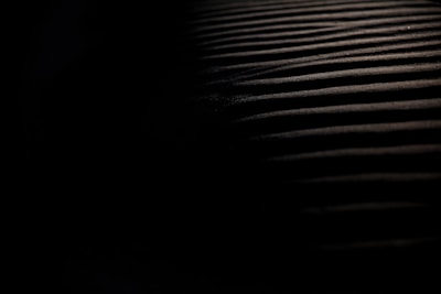 Close-up of overlapping shadows on a dark surface with mysterious glowing lines.