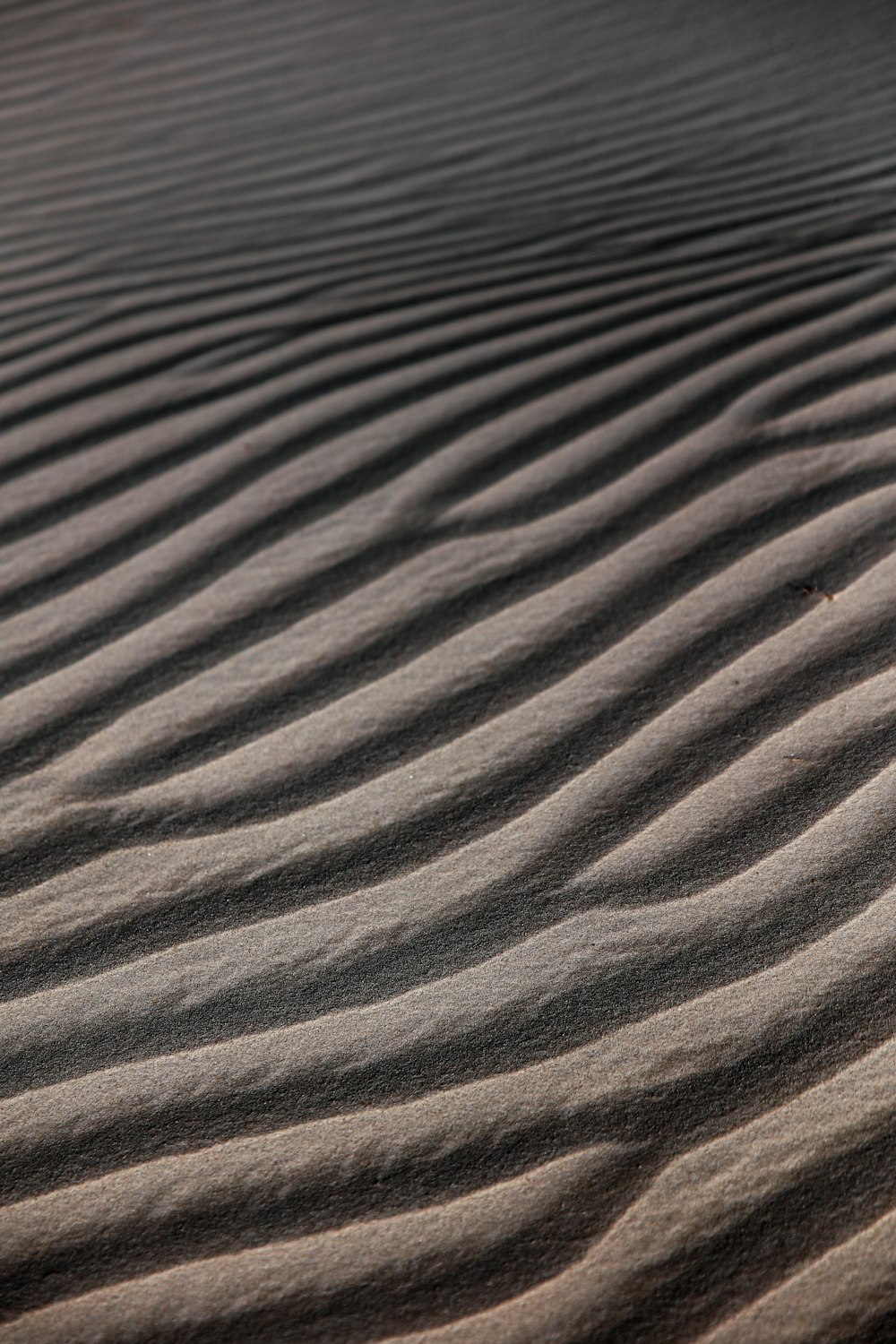 a sand dune with wavy lines in the sand