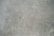 A textured grey concrete surface with visible scratches and variations in shading.