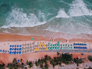 aerial view of brown sand near body of water during daytime