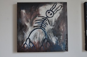 A surreal painting featuring a skeletal figure with rabbit-like ears against a dark, abstract background. The figure is outlined in bold, black strokes with circular eyes and rib-like structures extending down its body. The background blends shades of gray, dark brown, and white, giving the piece a mysterious and moody atmosphere.