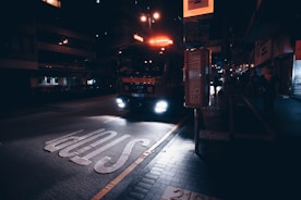 Red intense emergency lights flashing on a black tow truck at night