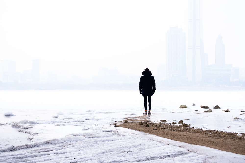 person standing on seashore during daytime