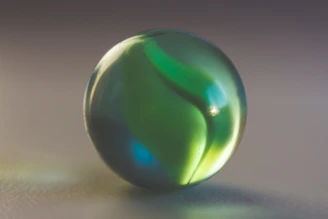 A smooth black marble rolling gently on a white surface, symbolizing momentum.