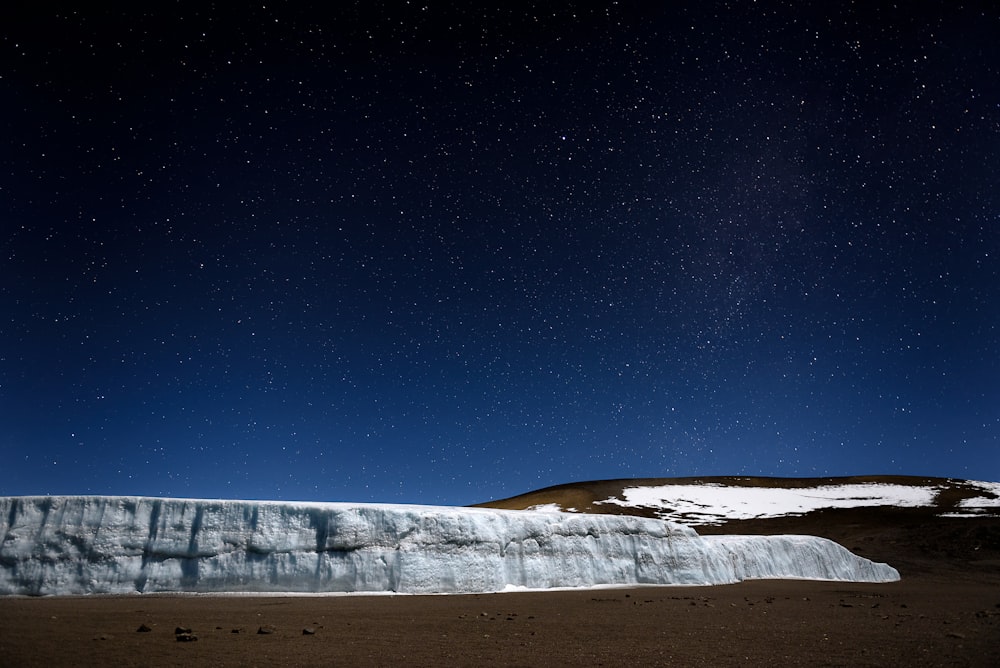 Montaña blanca y marrón bajo la noche estrellada