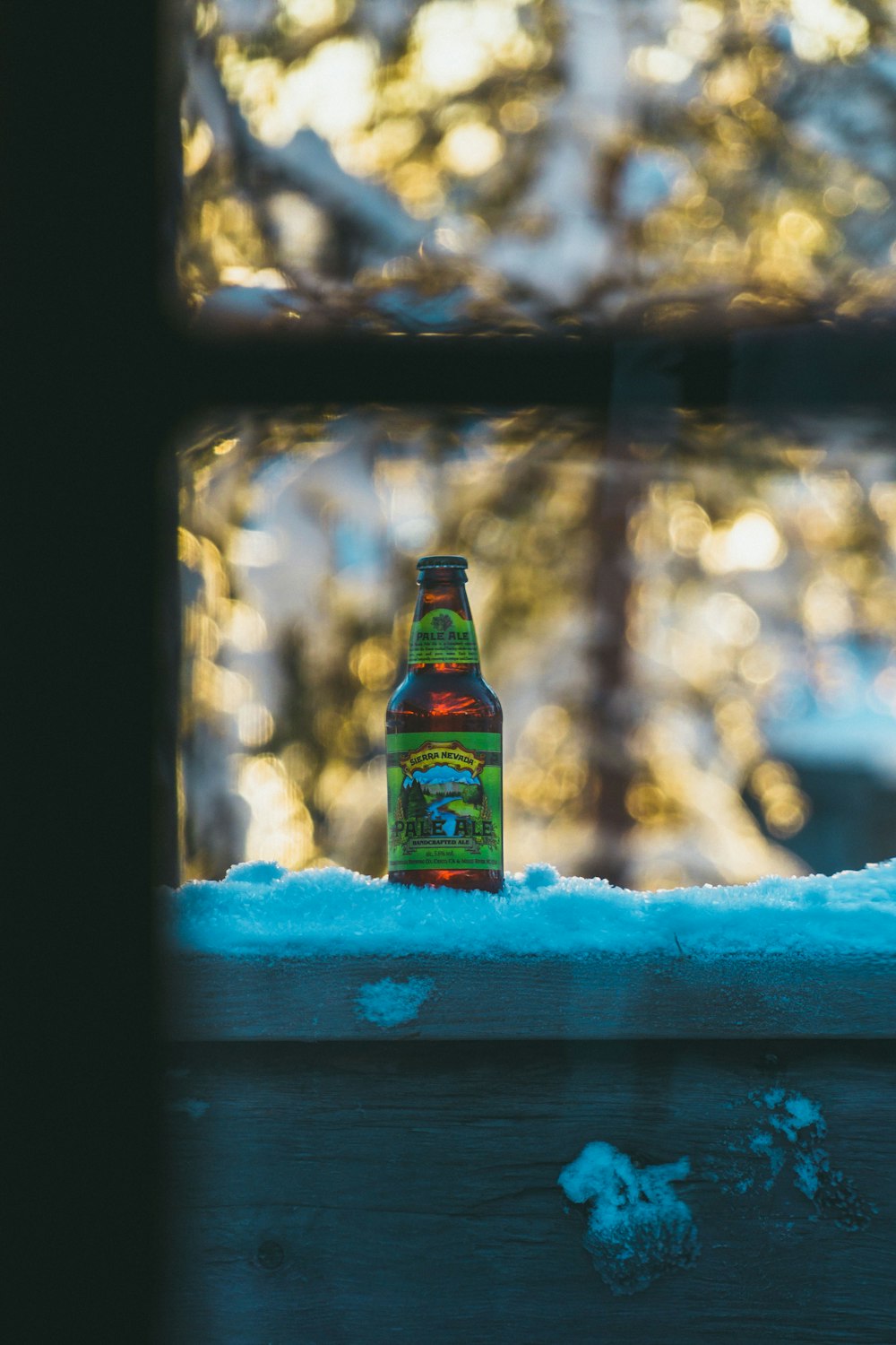 bouteille en verre marron sur neige