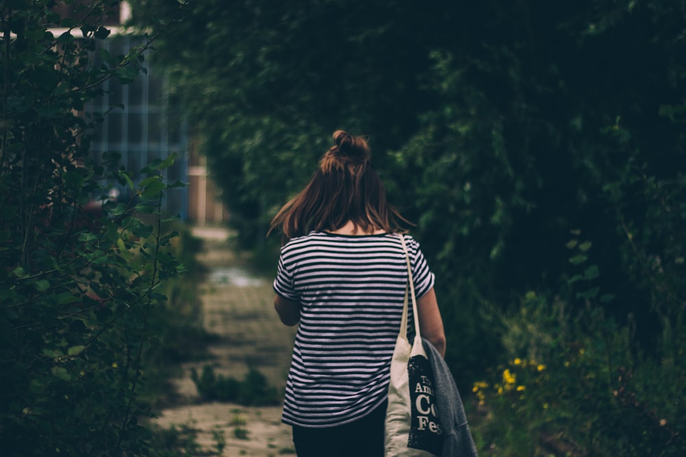 woman in black and white striped shirt carrying black and white backpack