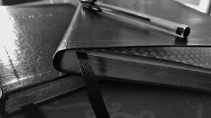 Close-up of legal books and documents with a pen resting on top.