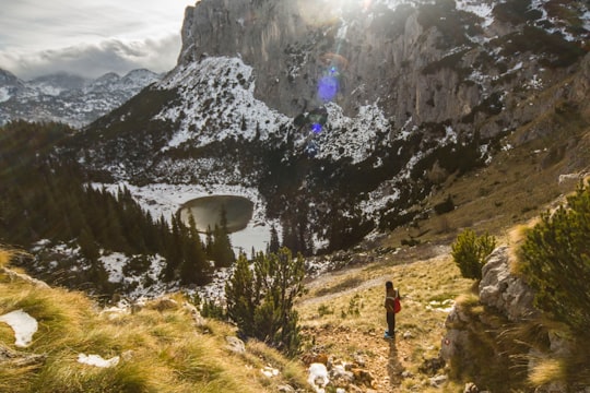 person standing on hill with lake on valley in Durmitor Nacionalni Park Montenegro