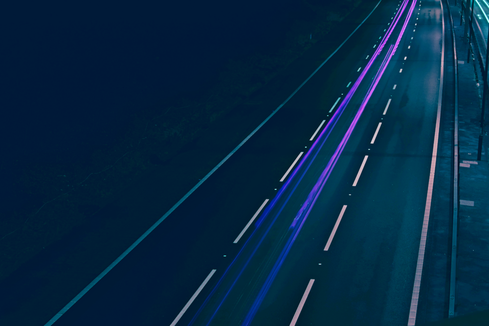 timelapse photography of blacktop road with purple light