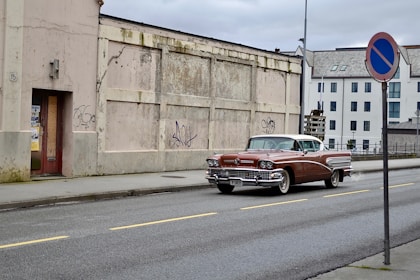 red Chevrolet Bel Air parked near brown building