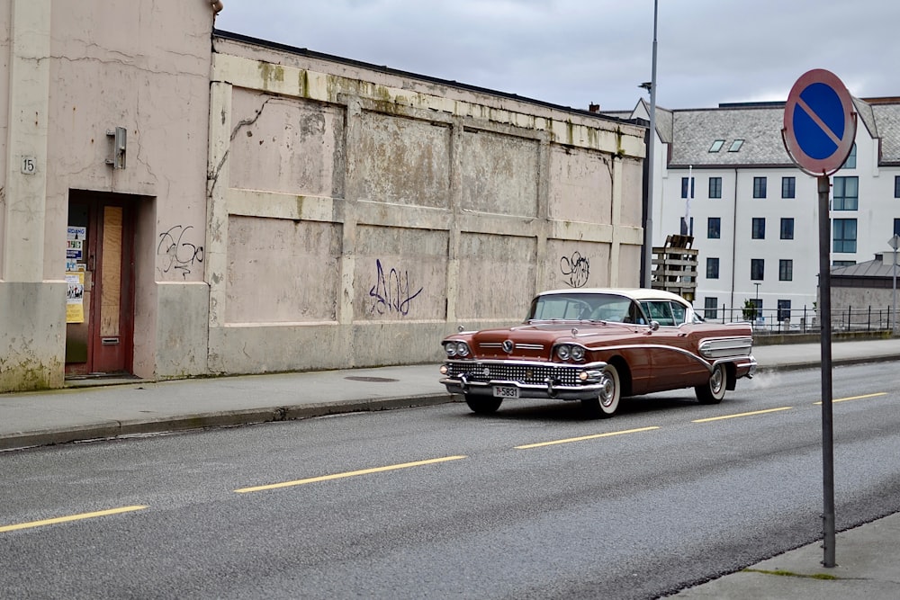 red Chevrolet Bel Air parked near brown building