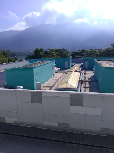 A Blue Shield Maintenance Group technician inspecting HVAC equipment on a sunny rooftop.