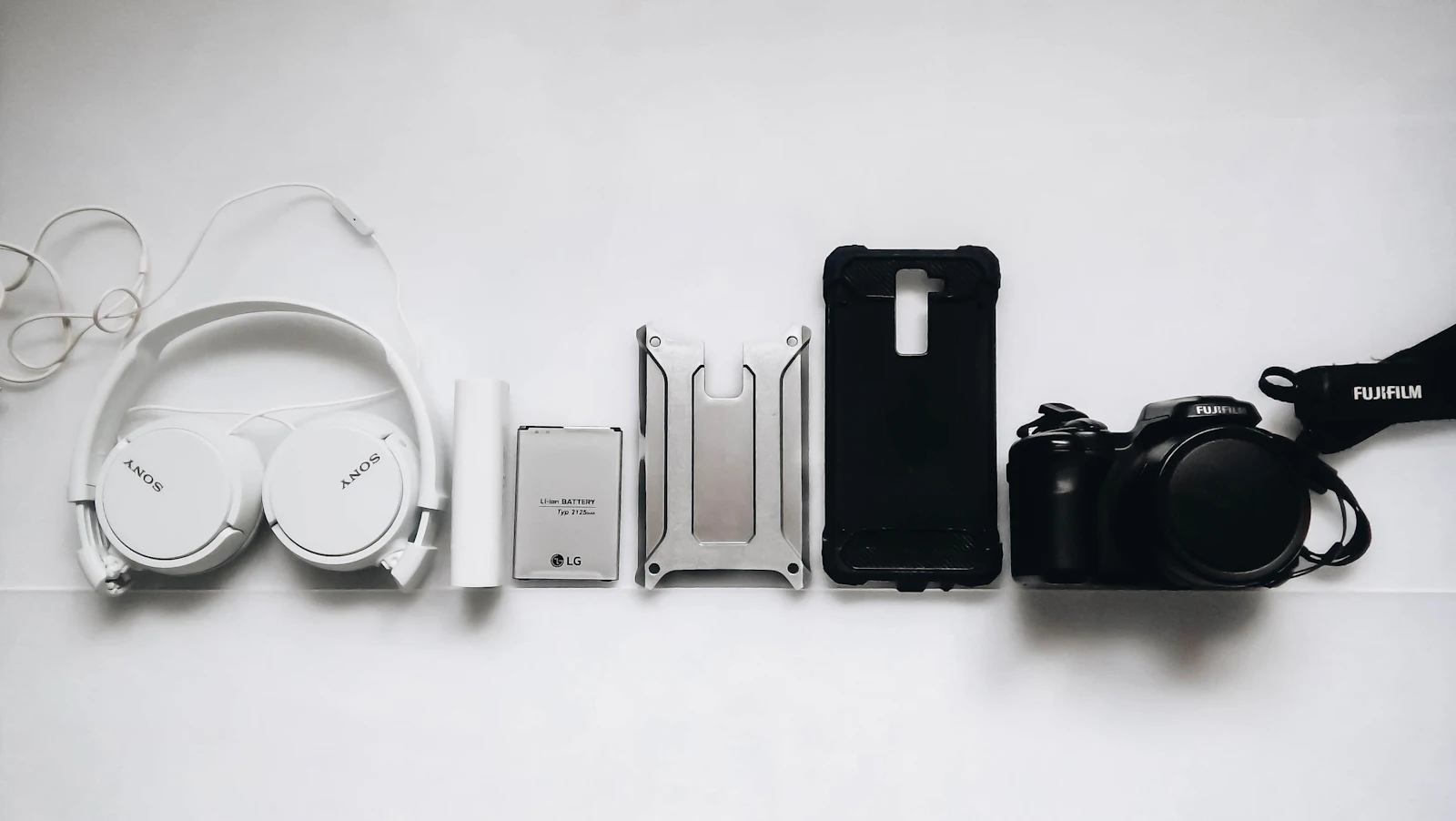 White Sony headphones next to a black smartphone case