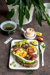 A colorful plate with a freshly made gourmet sandwich and fresh greens.