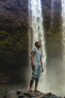 An ethereal shot of Periel singing barefoot on a moss-covered rock beside a gentle stream.