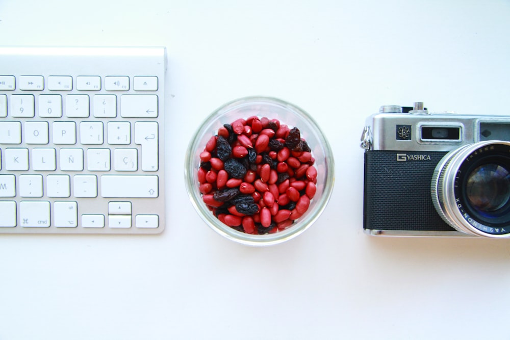 appareil photo reflex noir et gris et clavier blanc