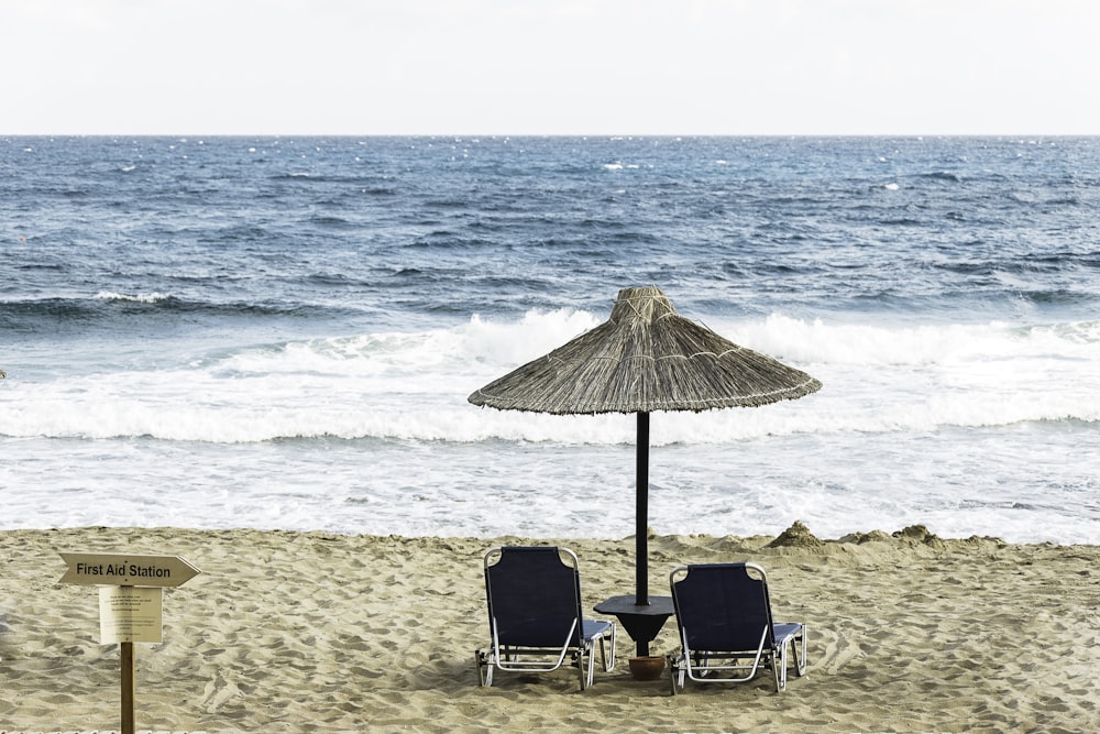 deux chaises de plage noires au bord de la mer