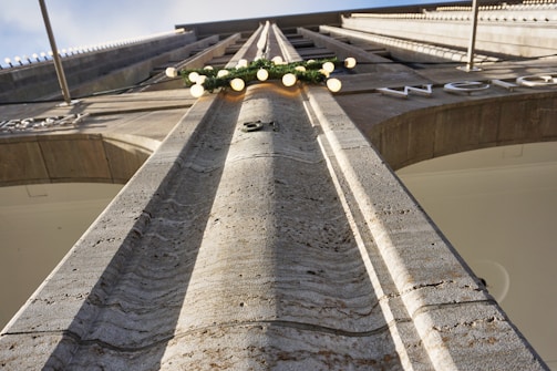 Close-up of textured stone facade illuminated against a dark sky.