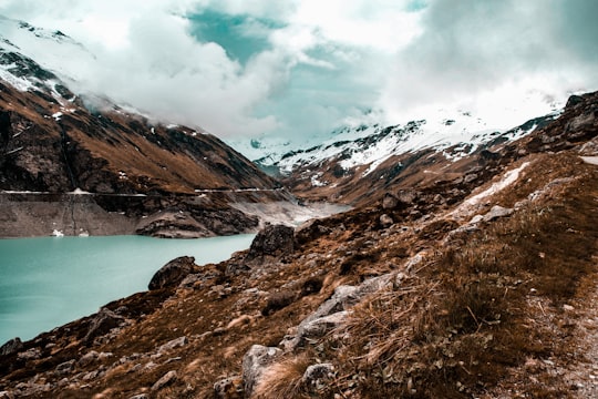 body of water surrounded with mountain in Lac de Moiry Switzerland