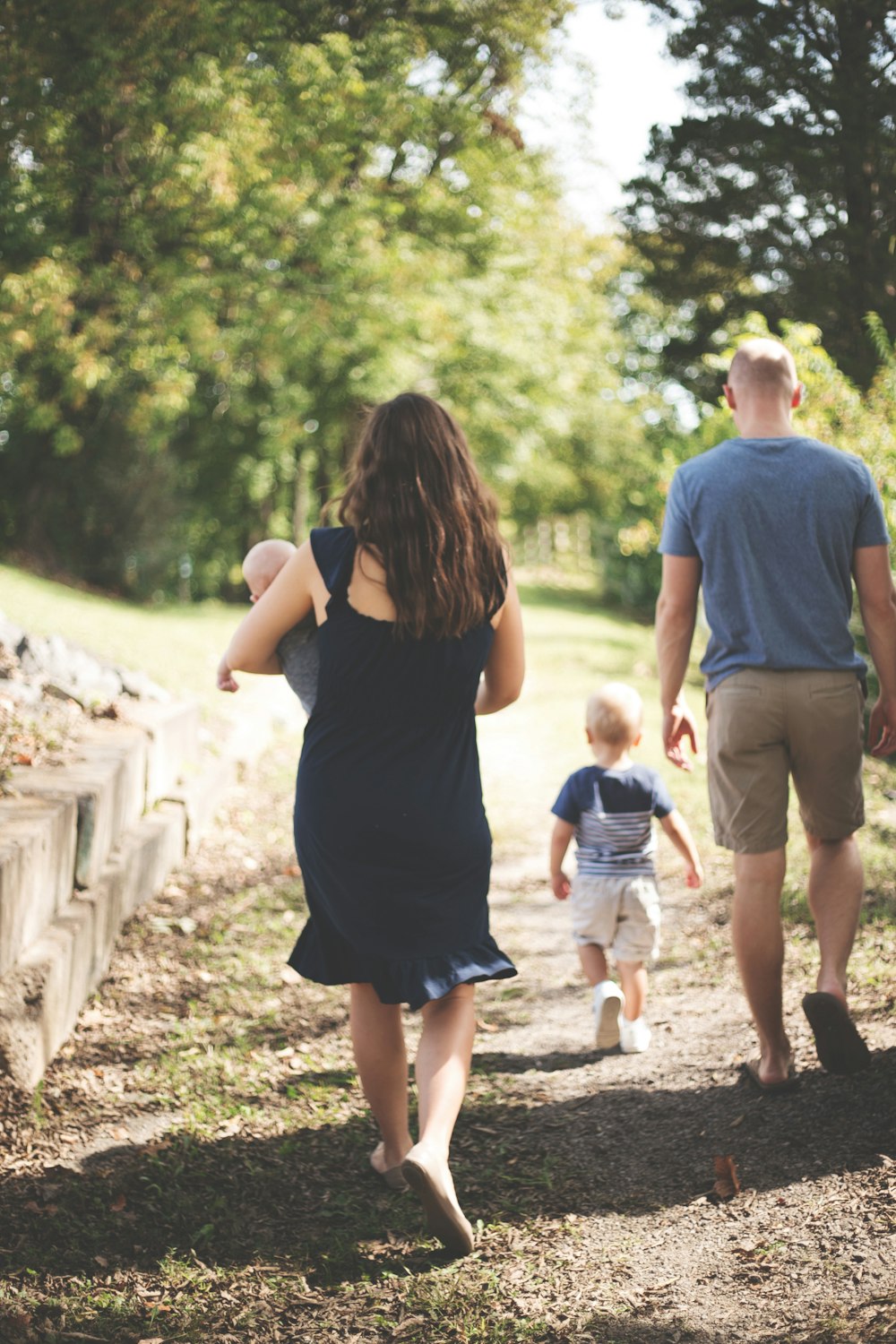 woman carrying baby near man