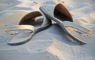 pair of beige sandals on sand
