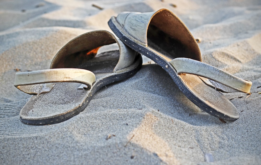 pair of beige sandals on sand