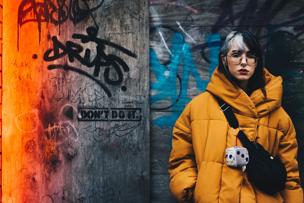 woman standing on gray graffiti wall