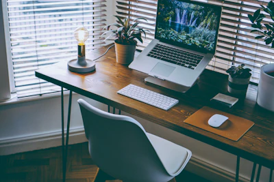A warm, inviting workspace with soft natural light highlighting a wooden desk and a laptop.
