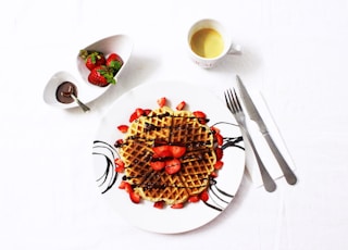 flat lay photo of waffle with strawberries on plate