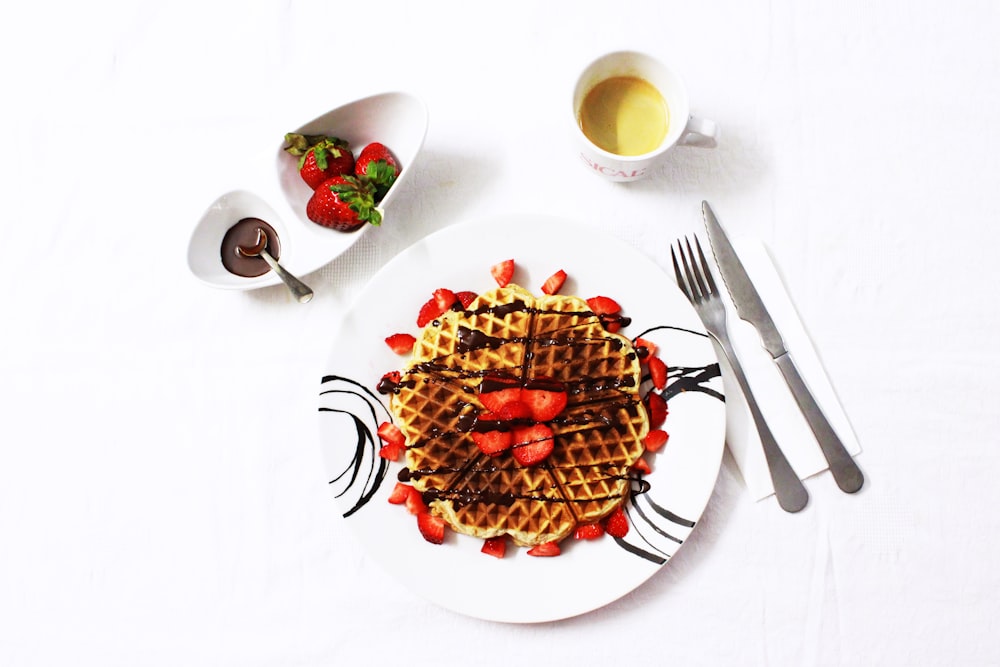 flat lay photo of waffle with strawberries on plate