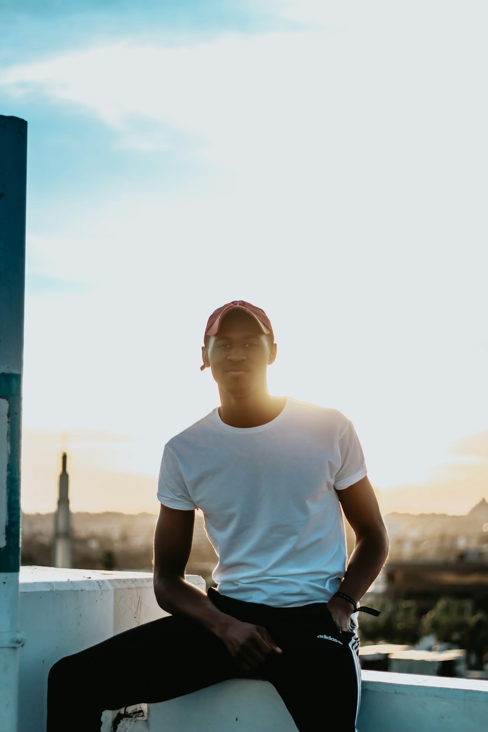 men's white crew-neck shirt while sitting on white corner