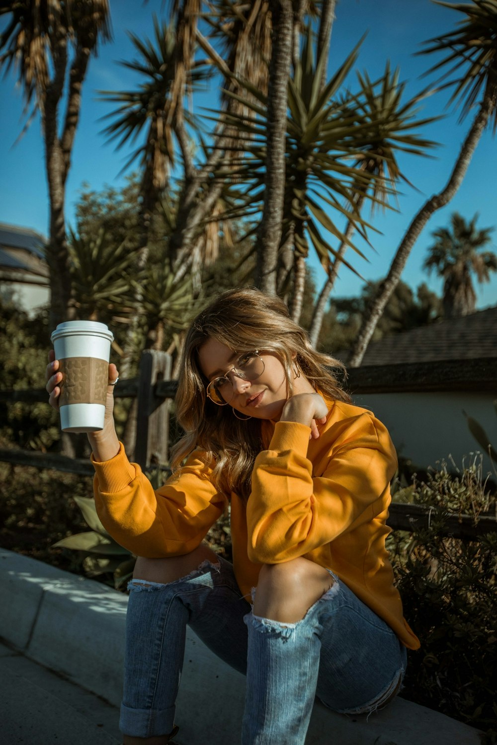 selective focus photography of sitting woman holding disposable cup