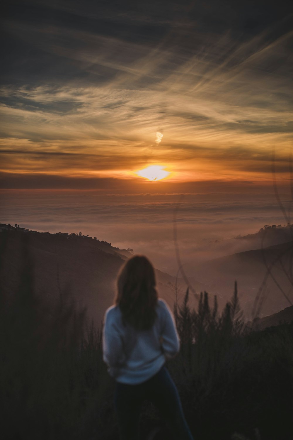 Mujer mirando fijamente la puesta de sol