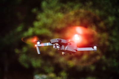 selective focus photography of drone flying on mid-air during nighttime