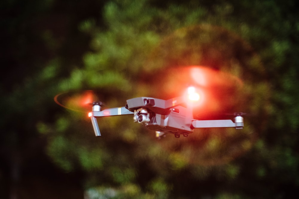 selective focus photography of drone flying on mid-air during nighttime