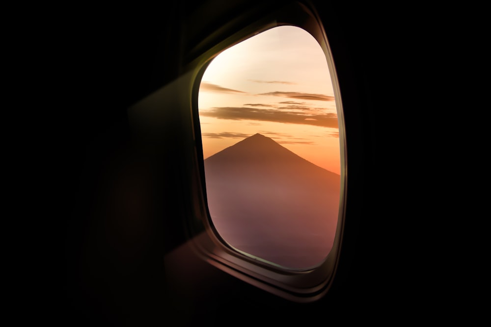 an airplane window with a view of a mountain