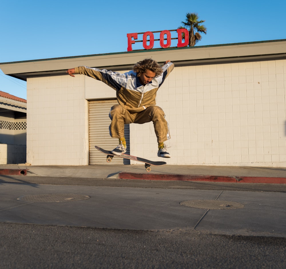 uomo che fa un salto skateboard trick