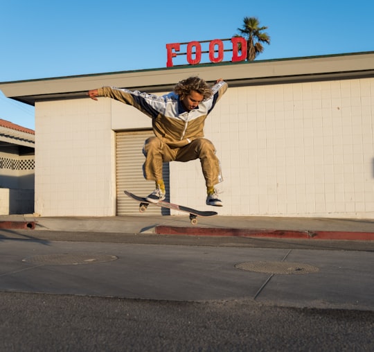 man making a jump skateboard trick in Zuma Beach United States